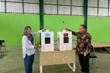 Kenakan Batik dengan Corak Emas, Madri Pani bersama Istri Mencoblos di TPS 02 Kampung Gurimbang