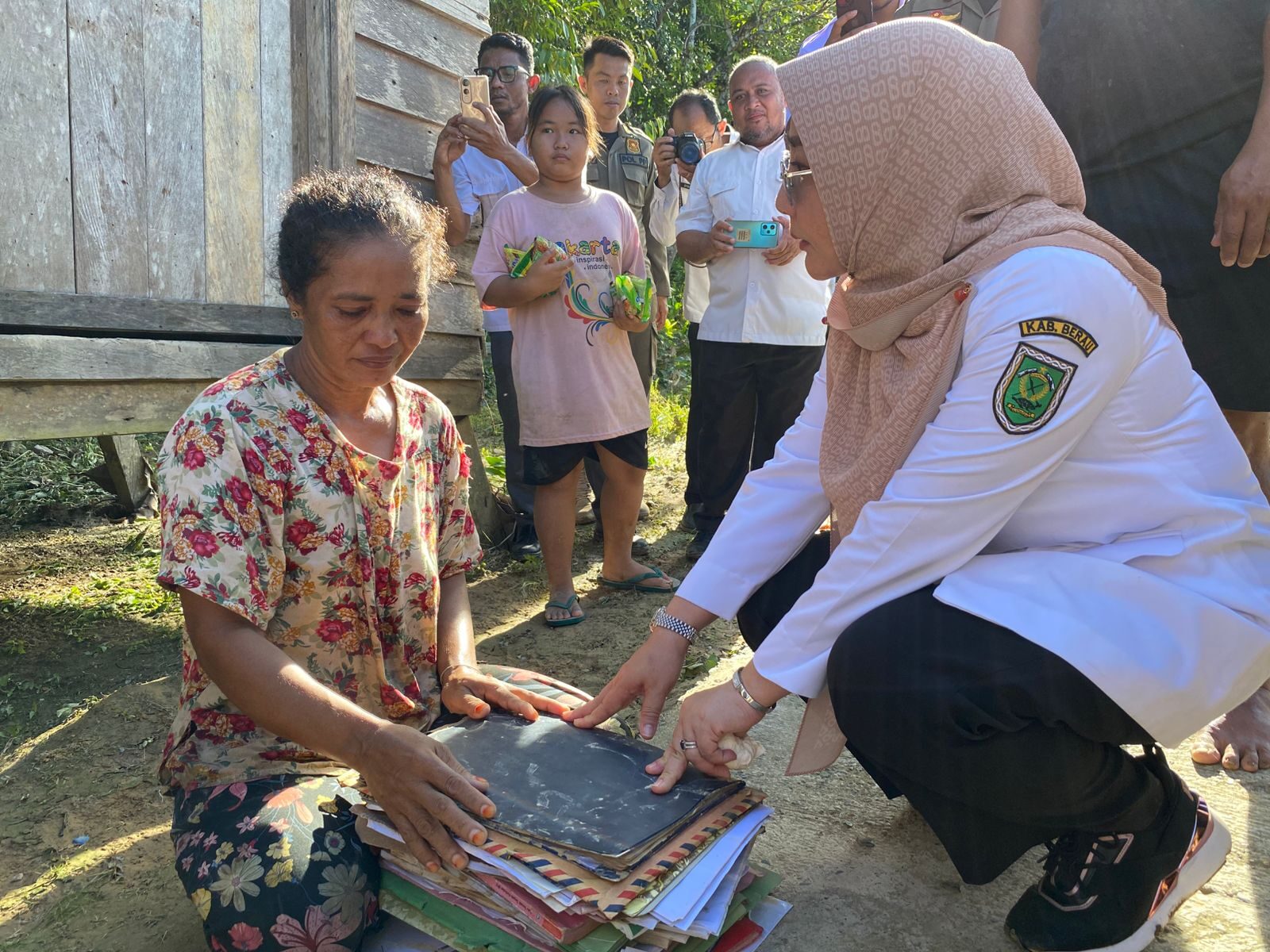 Bupati Berau, Sri Juniarsih, bersama salah satu warga yang sedang menjemur dokumen pribadi akibat bencana banjir pada akhir Mei lalu. (Sulaiman/BT)