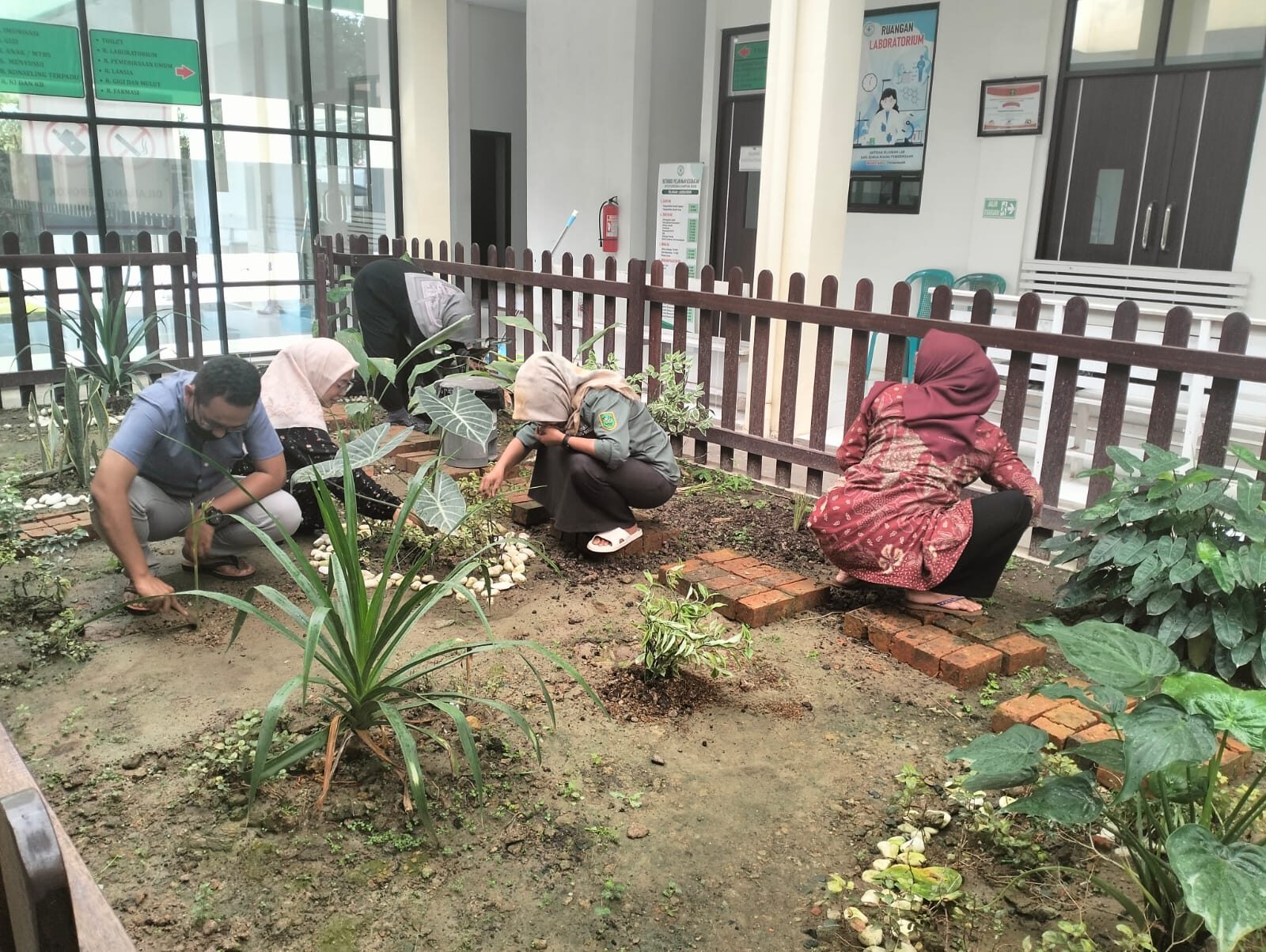Para pegawai kesehatan sedang merawat tanaman obat di lingkungan Puskesmas Kampung Bugis pada jam kerja. (Istimewa)