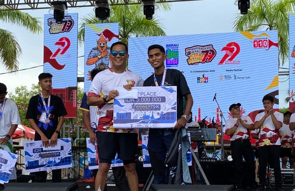 Kapolres Berau, AKBP Khairul Basyar, memberikan hadiah kepada Ibnu Sidik sebagai pemenang pertama Bhayangkara Berau Fun Run 2025. (Sulaiman/BT)