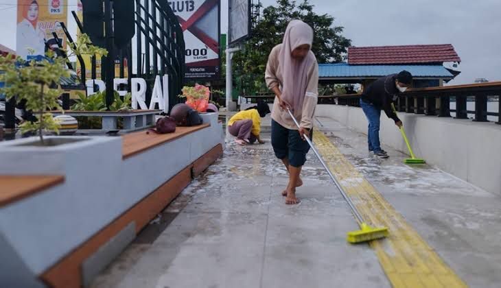 Pedagang sedang membersihkan lokasi jualan di kawasan tepian Jalan Ahmad Yani. (Sulaiman/BT)