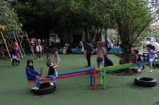 Ilustrasi anak bersama orang tuanya sedang bermain di taman.