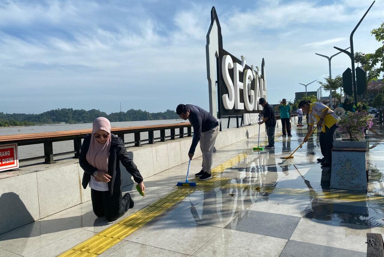 Bupati Berau, Sri Juniarsih, saat membersihkan lantai trotoar Tepian Jalan Ahmad Yani, Jumat (11/7/2025). (Sulaiman/BT)