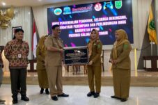 Pemberian penghargaan kelurahan ramah perempuan dan anak kepada Lurah Karang Ambun, Muliana, dari Plt Asisten II Setda Berau, Rusnan Hefni. (Sulaiman/BT)