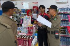 Petugas Satpol PP Berau memberikan imbauan kepada penjaga toko terkait jam operasi ritel modern. (Istimewa)