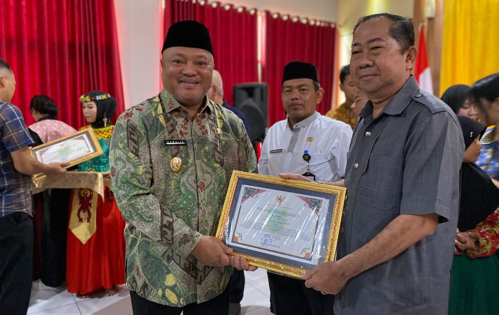 Wakil Bupati Berau Gamalis, memberikan piagam penghargaan kepada Ketua FKUB Berau, Datu Kesuma, sebagai pelopor toleransi umat beragama di Berau. (Sulaiman/BT)