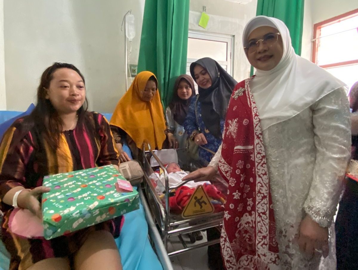 Ketua TP PKK Berau, Sri Aslinda Gamalis, memberikan bingkisan kepada Dewi Indah Sari yang melahirkan bayi pada Hari Kemerdekaan. (Sulaiman/BT)