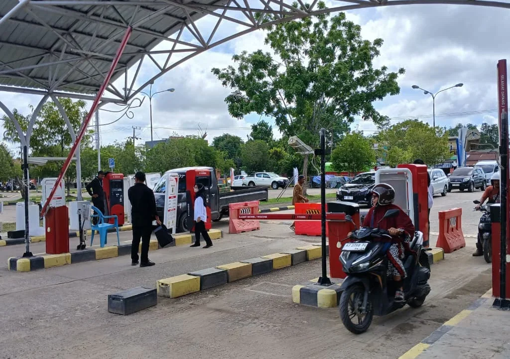 Suasana pintu masuk Pasar Sanggam Adji Dilayas saat pengunjung melewati mesin parkir elektronik, Senin (23/2/2026). (Adrikni/BT)