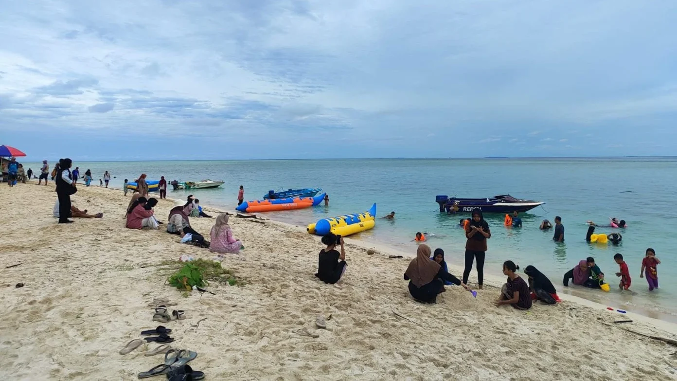 Wisatawan yang tengah bermain di pantai Pulau Derawan Berau.