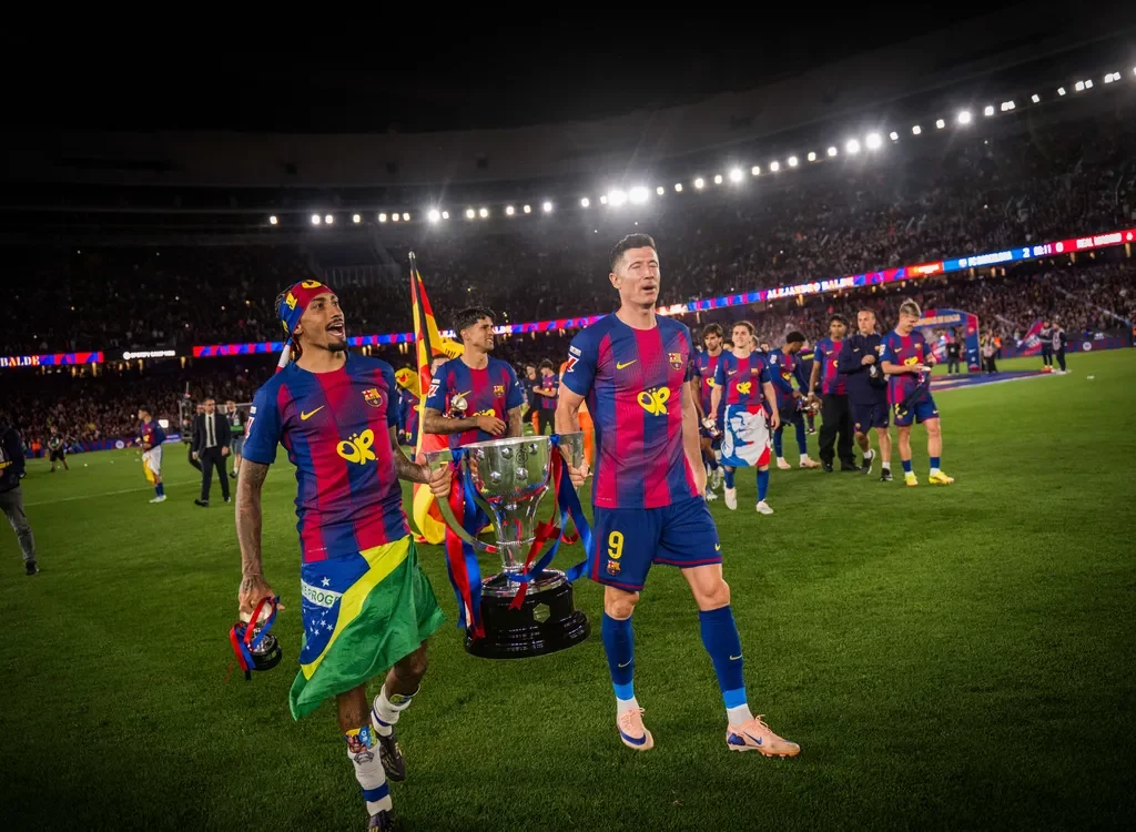 Robert Lewandowski bersama Rapinha menenteng trofi La Liga. (fcbarcelona.com)