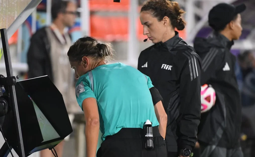 Ilustrasi wasit FIFA sedang mengecek VAR (theifab.com)