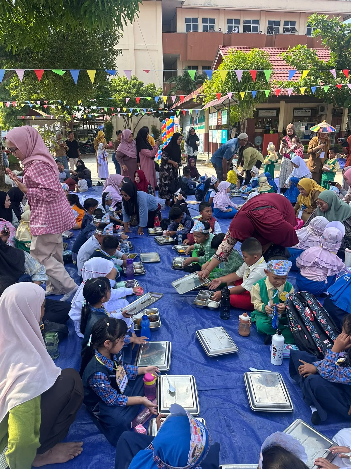 Murid baru SDN 007 Tanjung Redeb saat menyantap menu MBG didampingi orang tuanya, Senin (13/7/2026).