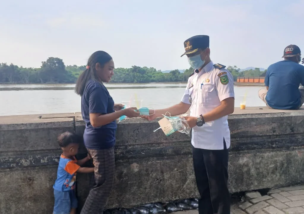 Forkopimcam Teluk Bayur saat membagi masker gratis kepada warga di kawasan Teras Bandara Kalimarau, Rabu (26/8/2026). (Adrikni/BT)
