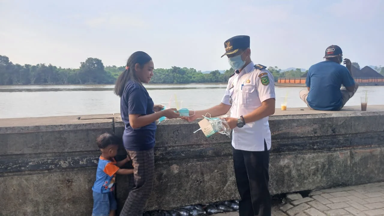 Forkopimcam Teluk Bayur saat membagi masker gratis kepada warga di kawasan Teras Bandara Kalimarau, Rabu (26/8/2026). (Adrikni/BT)