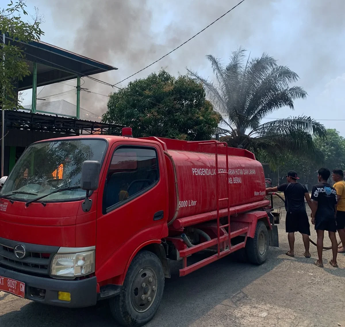 Mobil pemadam kebakaran yang tengah memadamkan api di rumah yang terbakar di Jalan RA Kartini, RT 15 Kampung Talisayan, Kecamatan Talisayan, Sabtu (26/9/2026).